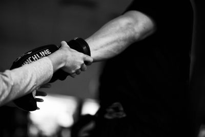 Close-up of referee examining gloves of boxer