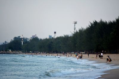 People on beach against clear sky