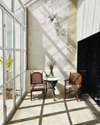 Empty chairs and table against window at home