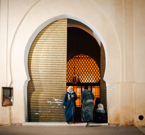 Rear view of people walking on entrance of building