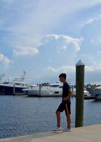 Full length of man standing at harbor against sky