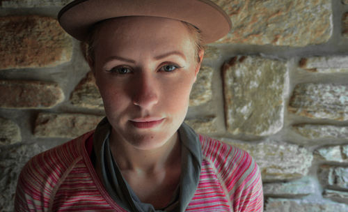 Portrait of young woman against wall