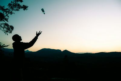 Woman jumping on landscape at sunset