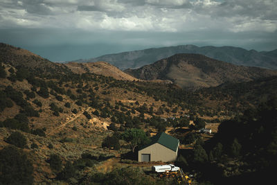 Scenic view of barn and farm against mountains and sky