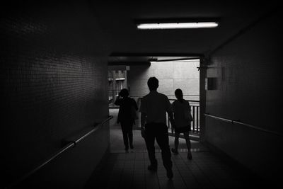 Silhouette man and women walking in corridor