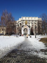 Buildings in city against clear sky during winter