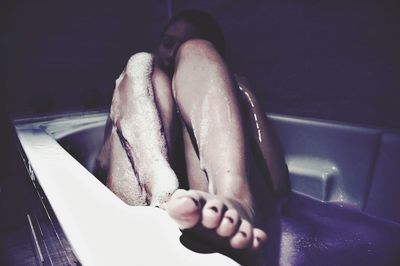 Full length of woman relaxing in bathtub