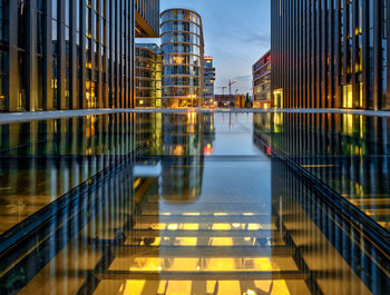 Illuminated modern building in city against sky