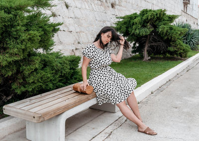 Full length of woman sitting on bench