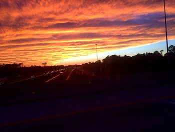 View of road against cloudy sky at sunset