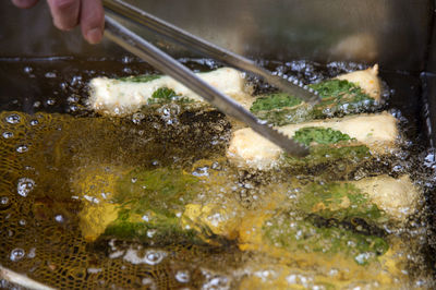 Cropped hand of vendor frying eomuks at market