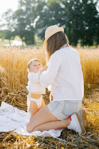 Mom changes the child's clothes on vacation in nature