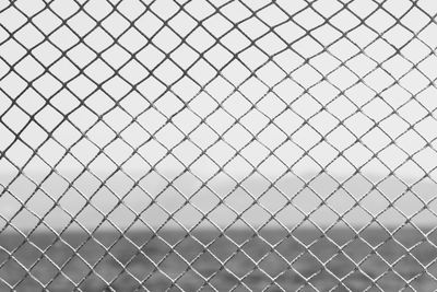 Low angle view of chainlink fence against sky