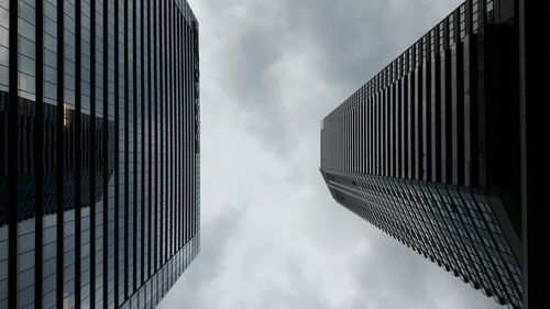 Low angle view of modern building against cloudy sky