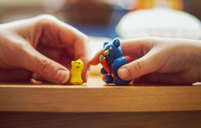 Close-up of hand holding toy on table