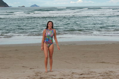 Full length of woman in bodysuit at beach