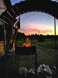 View of bonfire on field against sky at sunset