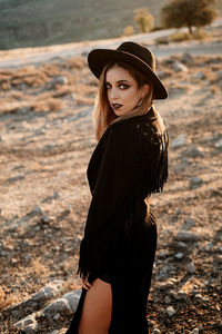 Young woman wearing hat standing on land