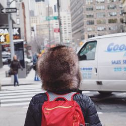 Rear view of person wearing furry hat on street
