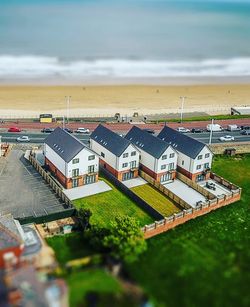 High angle view of houses by sea against sky