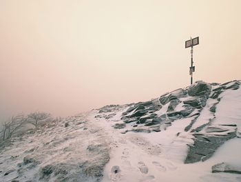 Rocky hill above inverse mist. winter cold weather in mountains colorful fog. misty prak in winter