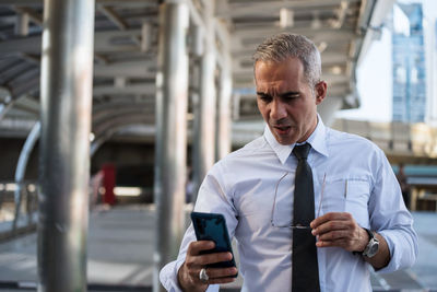 Businessman using smart phone outdoors