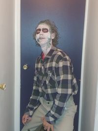 Portrait of young man standing by door