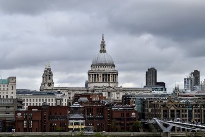 View of buildings in city against cloudy sky