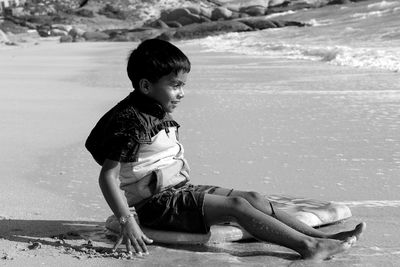 Girl looking at while sitting on beach