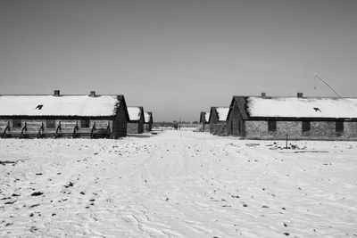 Houses on beach against clear sky during winter