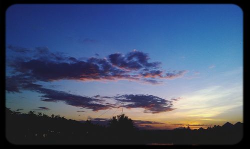 Silhouette of landscape against cloudy sky