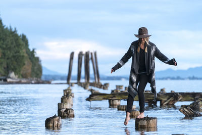 Teenage girl balancing along pier pilings at clayton beach