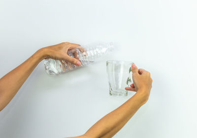 Midsection of man drinking glass against white background