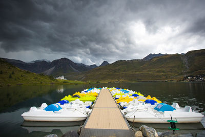 Tignes lake in the alps with pedal boats under a storm