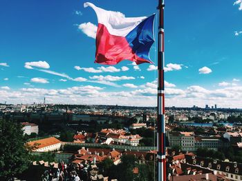 Czech flag waving by cityscape against sky