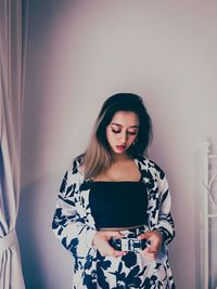 Young woman standing at home
