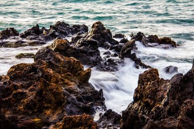 Long exposure of water flowing by rocks in sea 