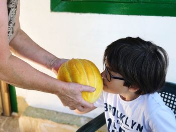 Cropped hands with melon holding by child