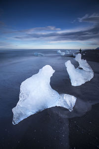 Frozen sea against sky during winter