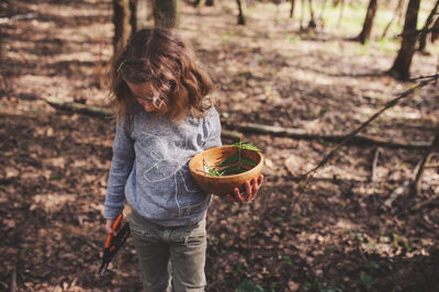 Midsection of girl holding fruit on field