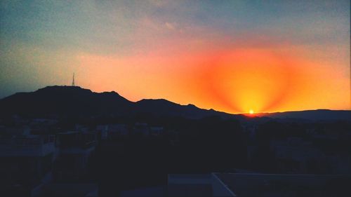 Silhouette cityscape against sky during sunset