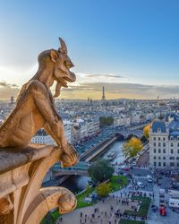 Statue in city against sky