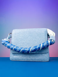 Close-up of purse against blue background