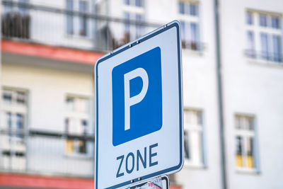 Close-up of road sign against blue city