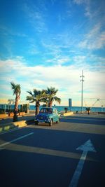 Cars on road against sky in city