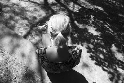 High angle view of woman sitting on street