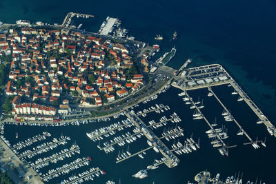 High angle view of illuminated modern buildings by sea at night