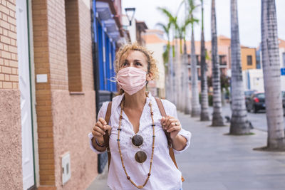 Young woman standing on street in city