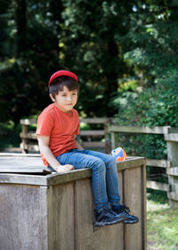 Portrait of boy sitting on bench
