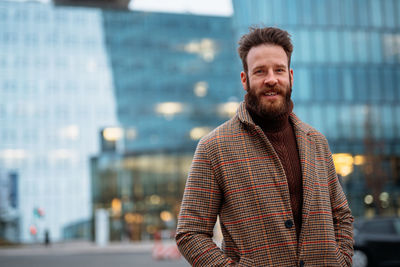 Portrait of man standing against building